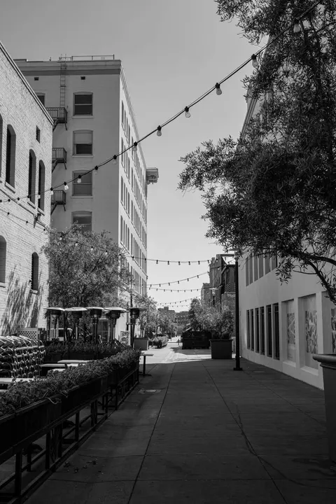 Black-and-white view of a restaurant patio alley strung with cafe lights in Los Angeles, CA